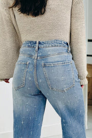 High-rise light wash denim jeans with distressed details and raw hem.