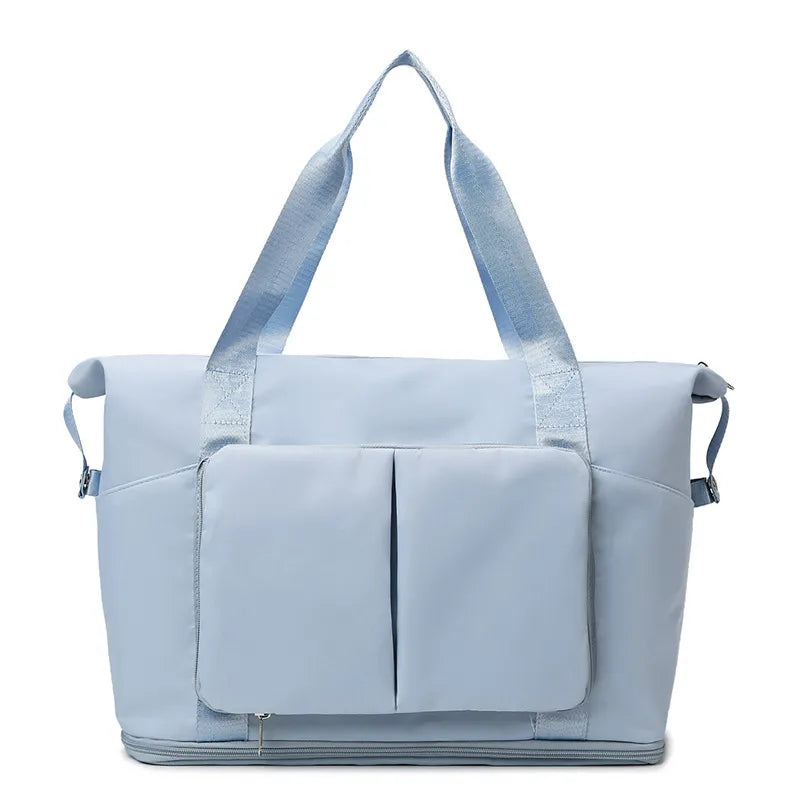 Light Blue foldable travel tote bag with dual exterior pockets and zipper closure.