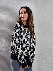 Black floral jacquard knit sweater with pink accents, crew neck, long sleeves.