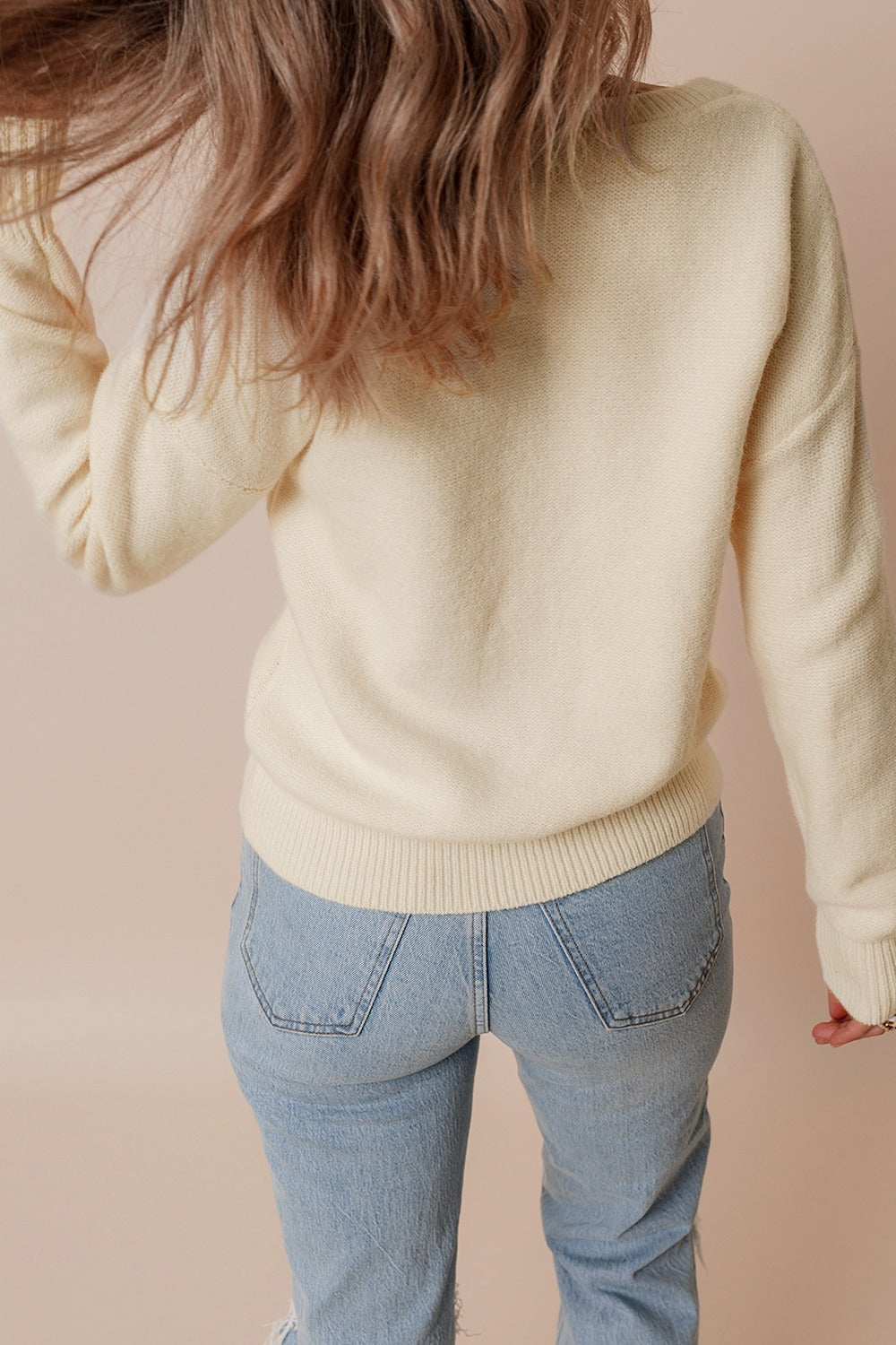 Cream knit sweater with ribbed cuffs and hem, crewneck, long sleeves.