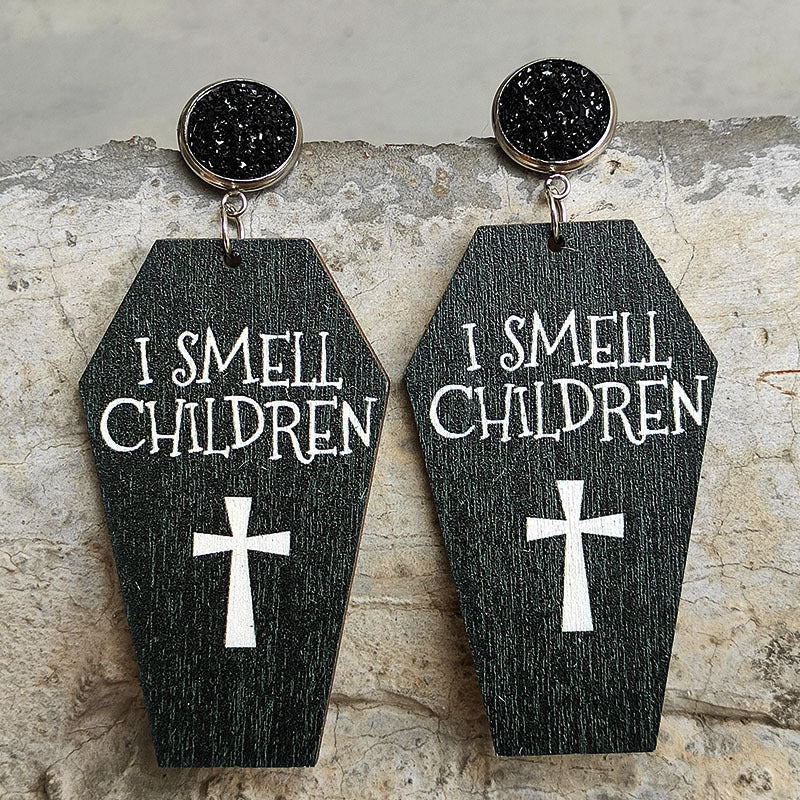 Gothic coffin earrings with white text I SMELL CHILDREN and a cross graphic.
