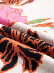 Knit sweater with floral and tiger print, featuring a stand neck and quarter zip detail.