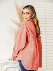 Orange-red distressed denim overshirt with raw hem and buttoned front.