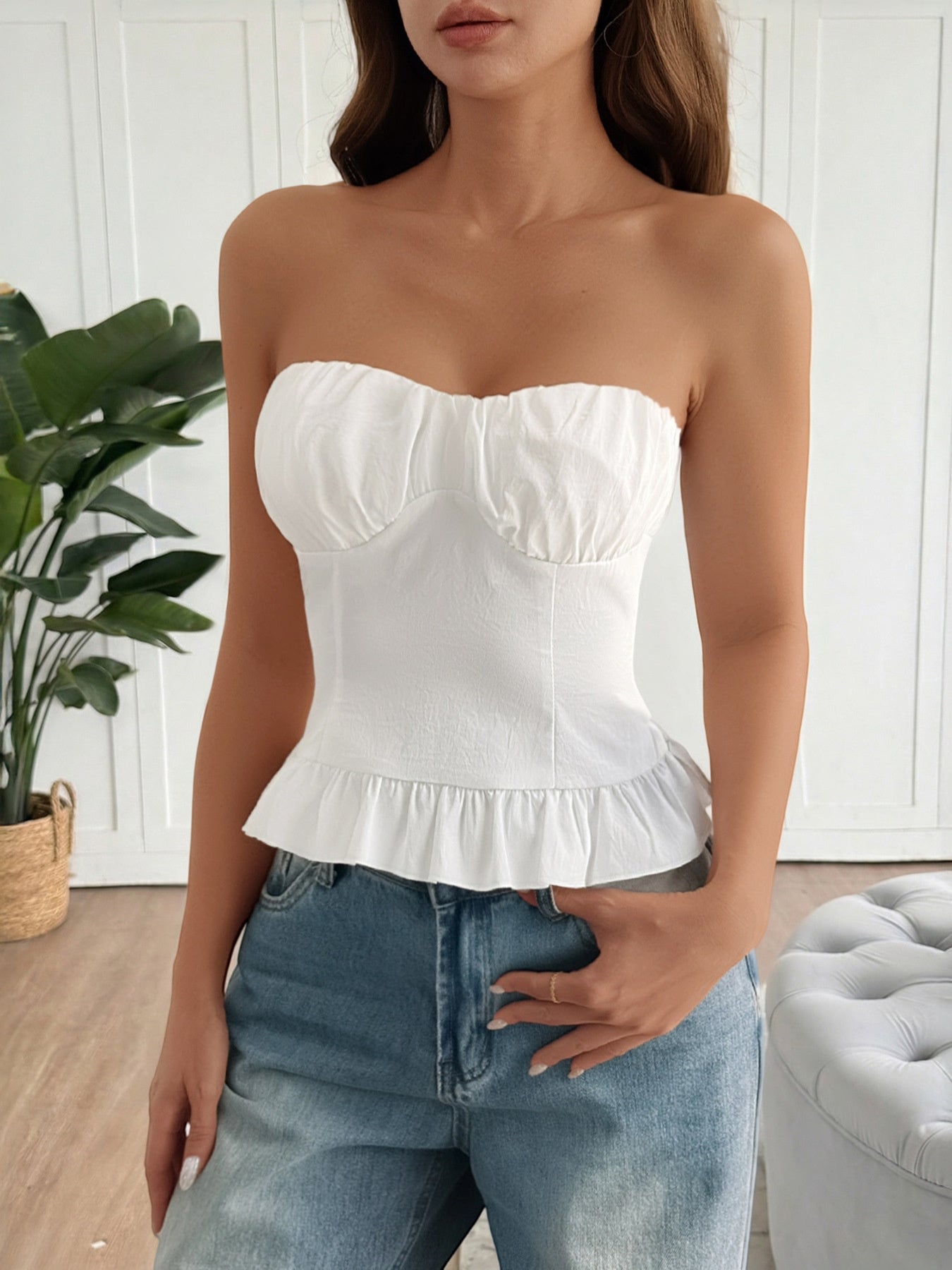 White ruffled hem strapless tube top with ruched bust detail.