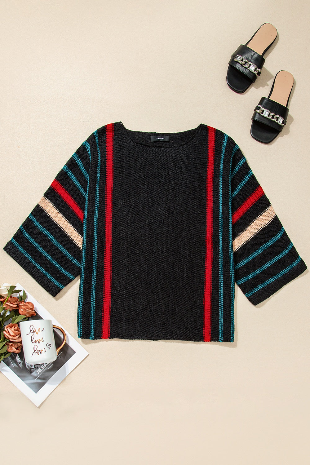 Black knit pullover with red, tan, and teal stripe details on sleeves and sides.