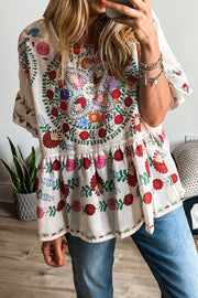 Embroidered medallion peplum blouse in floral with ruffled sleeves and neckline.