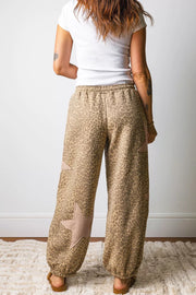 Leopard print relaxed fit pants in brown with star patches and elastic cuffs.