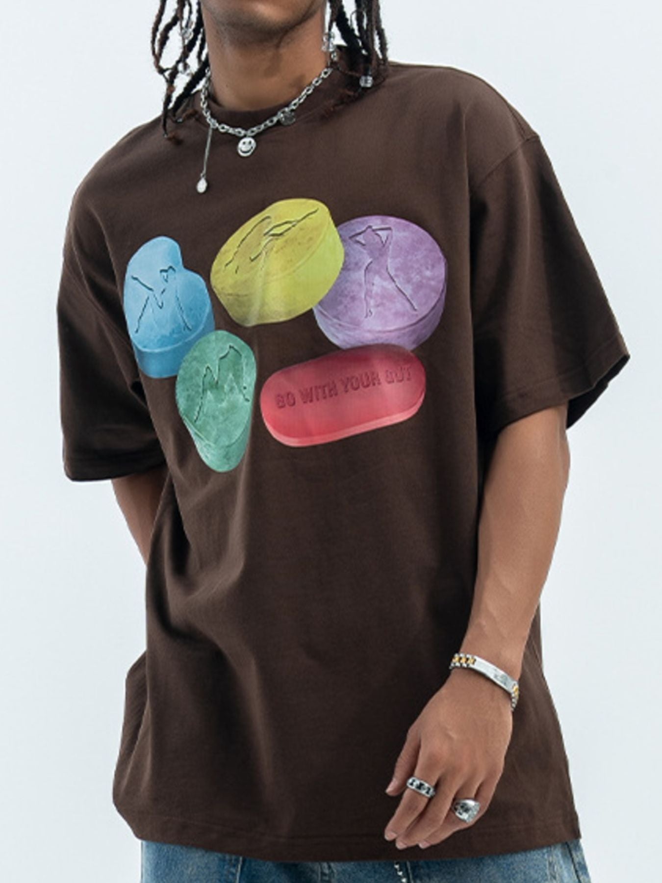Brown cotton crew neck t-shirt with graphic print of colorful pills and text.