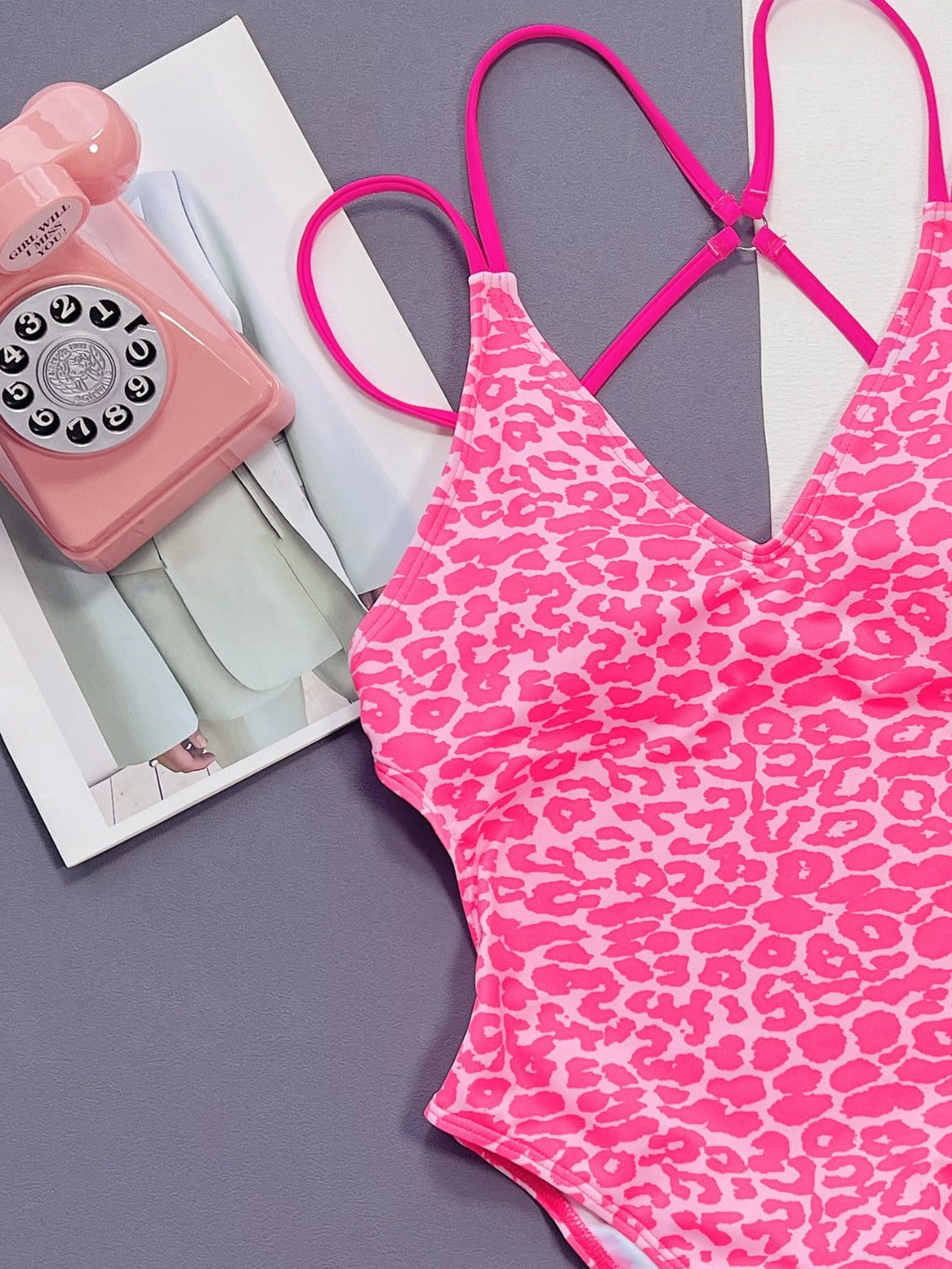 Hot pink leopard print one-piece swimsuit with strappy back detail.