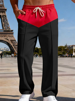 Two-tone relaxed fit men's sweatpants in black with a red chevron yoke and drawstring waist.