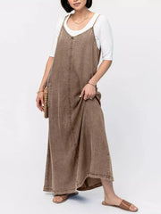 Brown washed denim maxi dress with V-neck and adjustable straps, styled with a white tee.