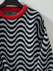 Black and white wavy stripe knit sweater with a red contrast collar.