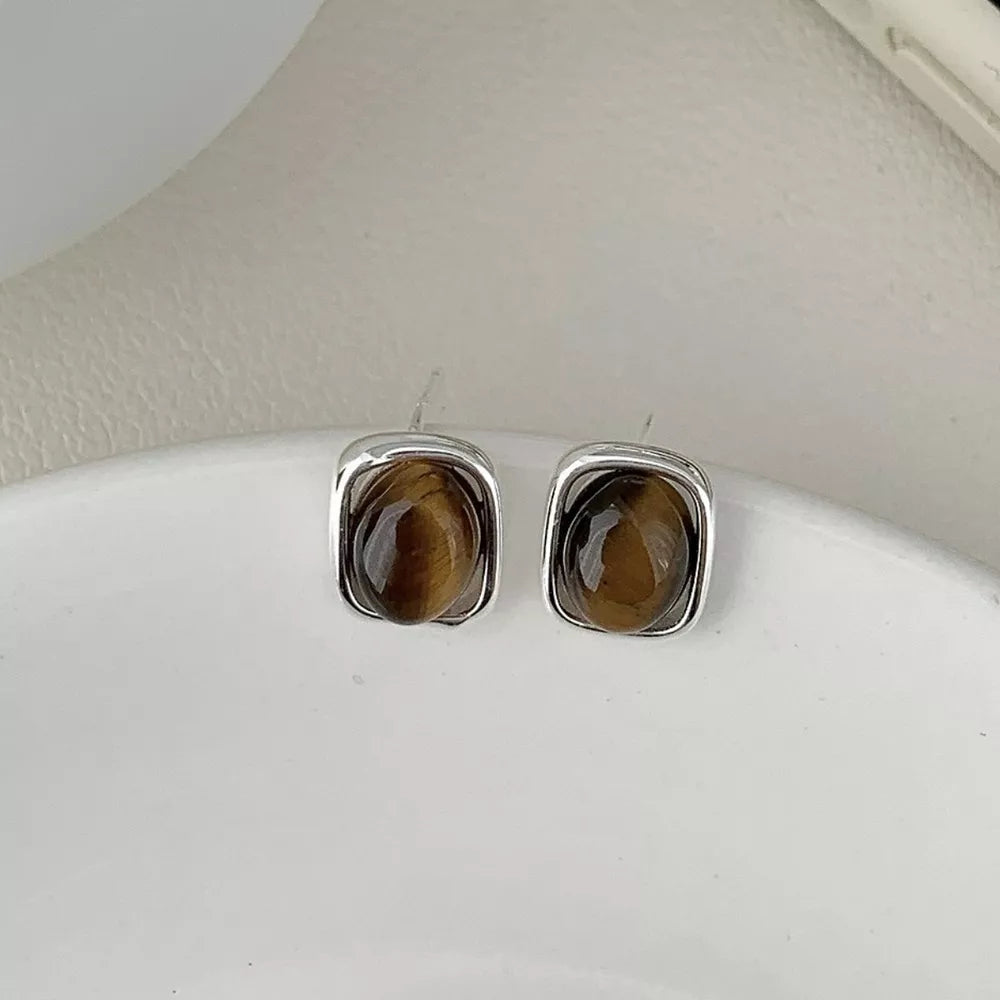 Silver square stud earrings with polished tiger eye gemstone centers