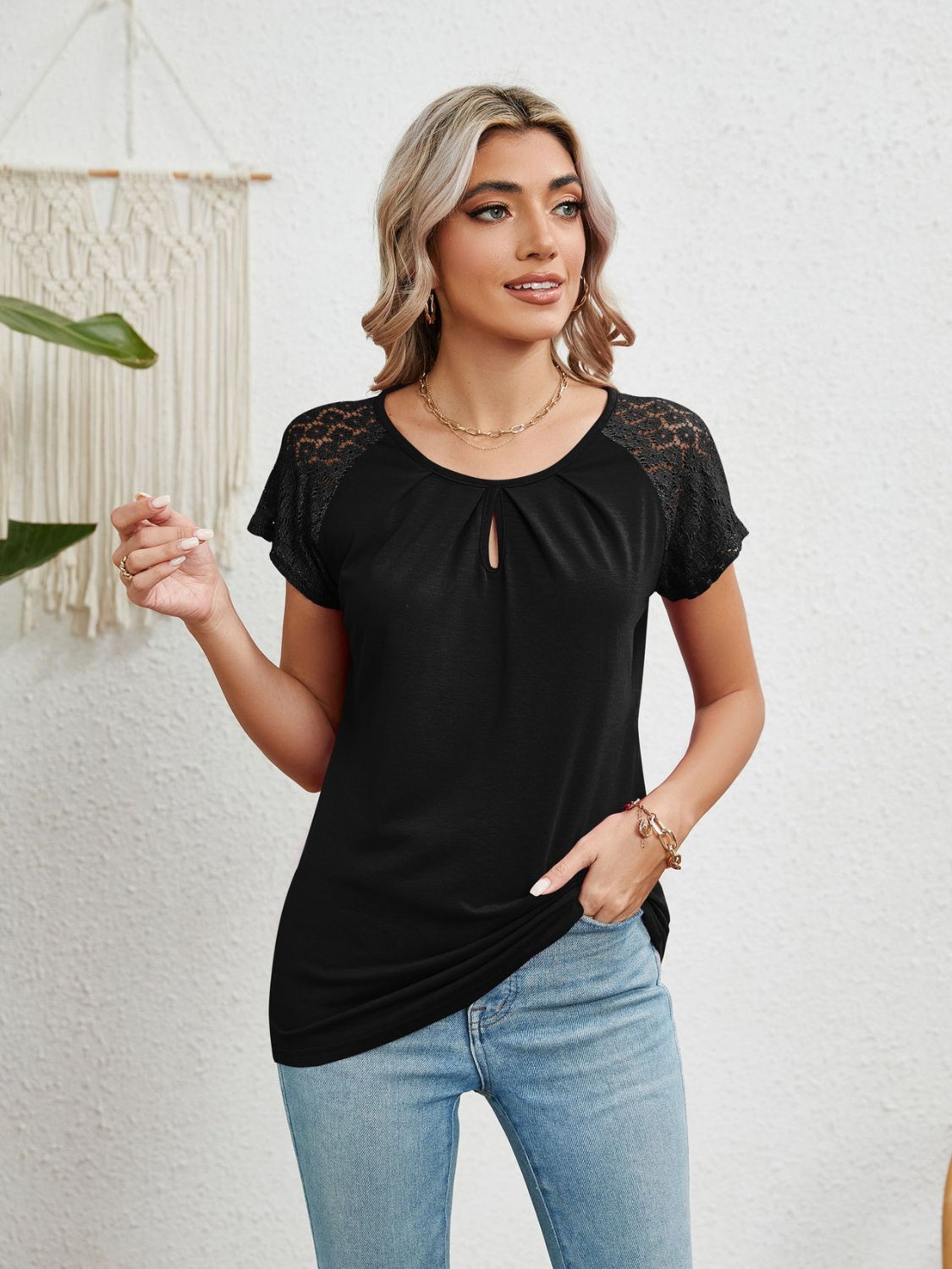 Black polyester blouse with lace sleeves, keyhole neckline, and short sleeves.