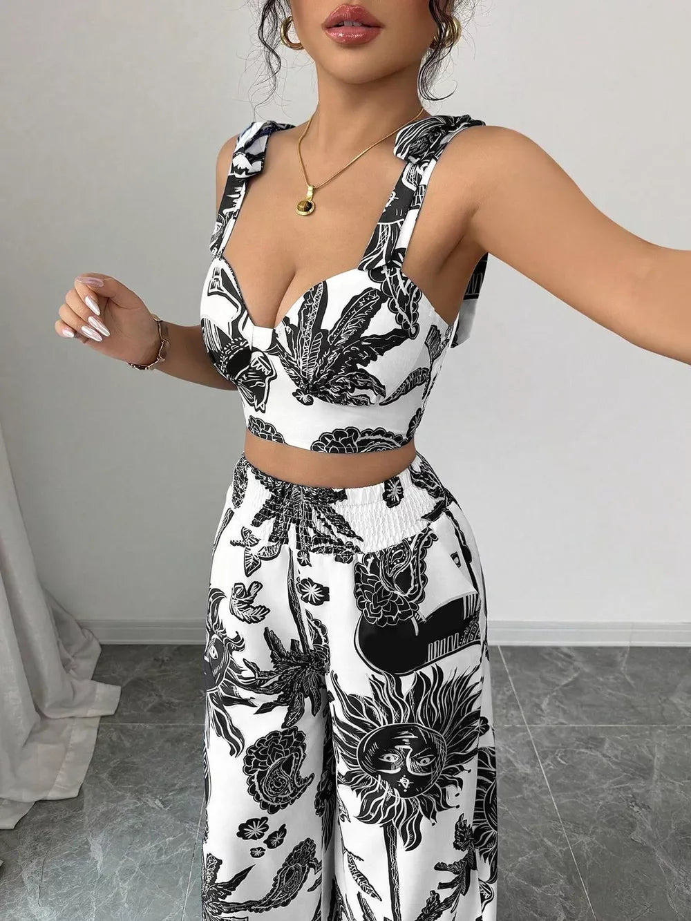 Black and white tropical print crop top with tie straps and wide-leg pants set.