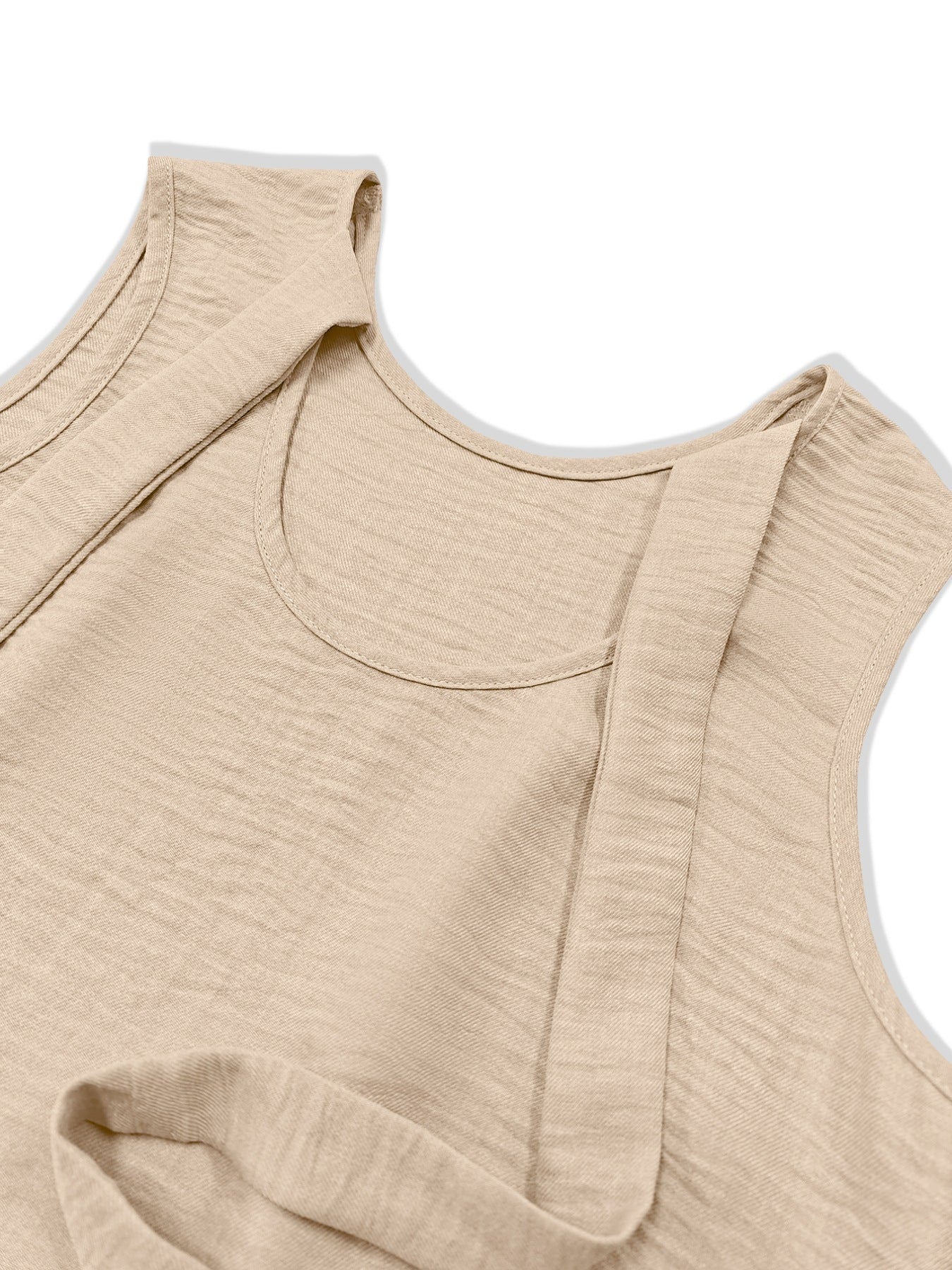 Beige backless mini dress with textured fabric and ruffled hem detail.