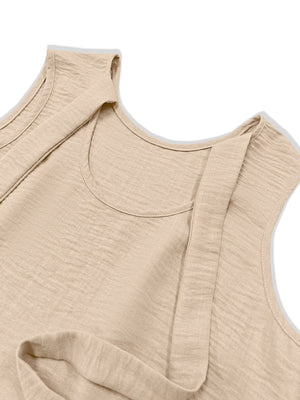 Beige backless mini dress with textured fabric and ruffled hem detail.