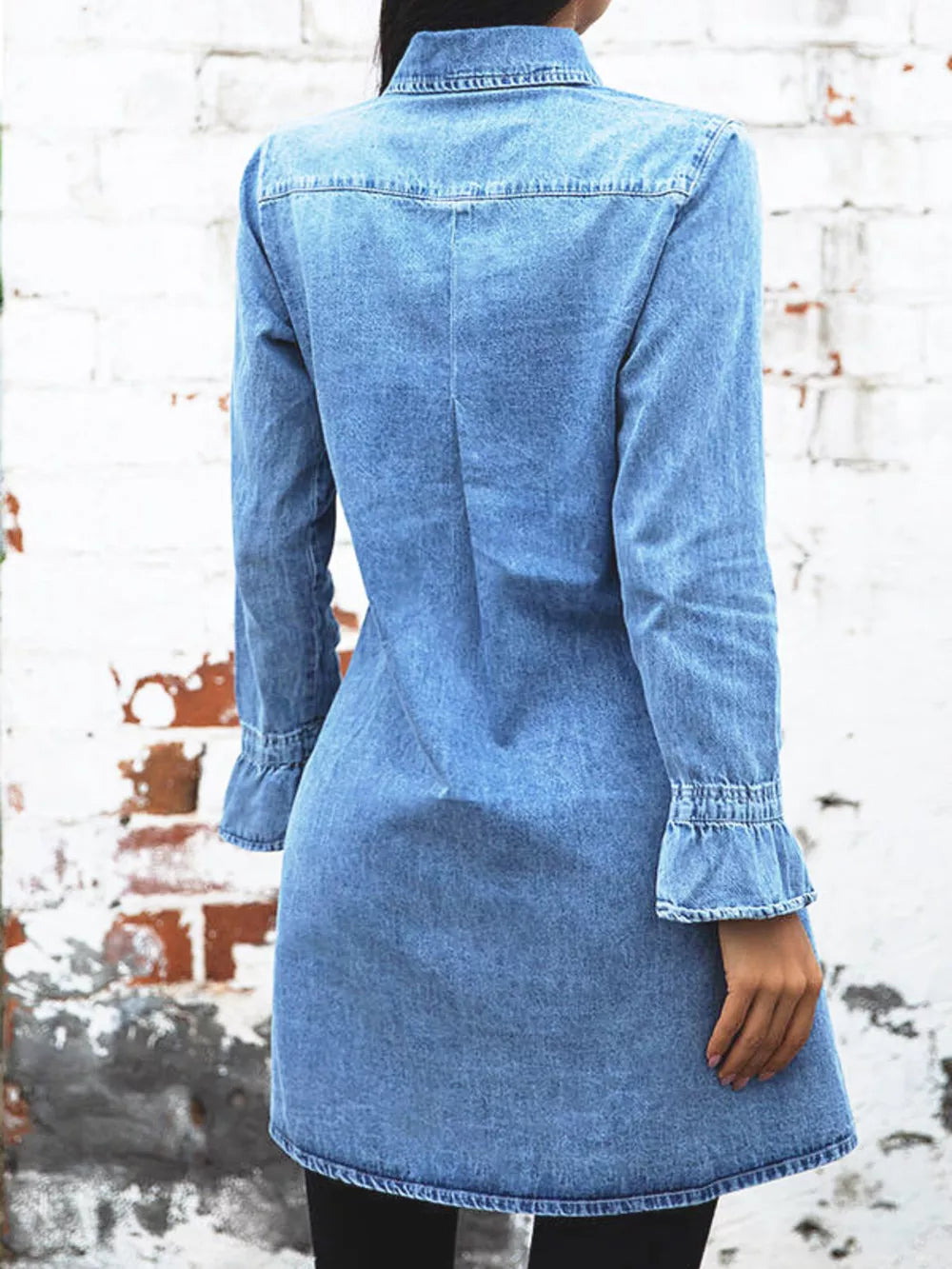 Denim dress with button front, long sleeves, and ruffled cuffs.