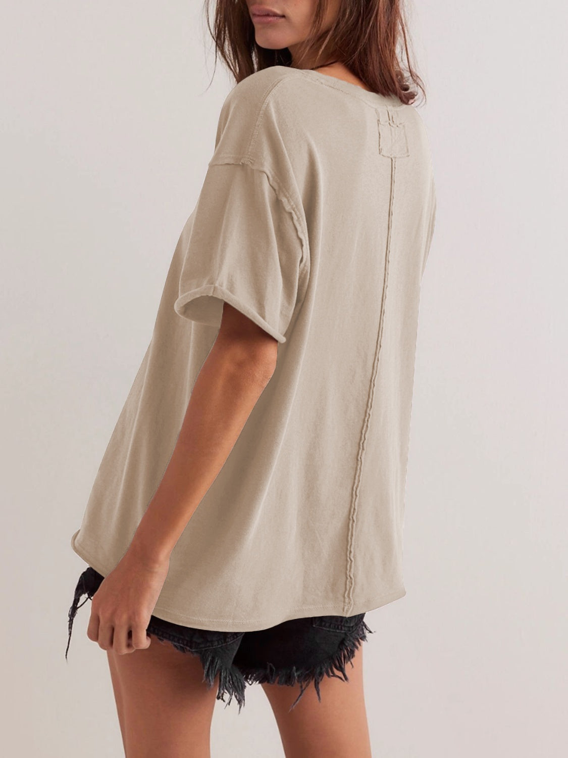 Oversized beige cotton tee with seam detail and raw hem sleeves.