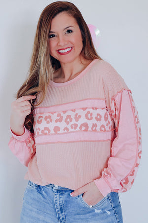Blush pink waffle knit top with leopard print panels and balloon sleeves.