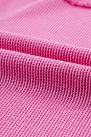 Waffle knit top in fuchsia pink cotton with raw seam detail.