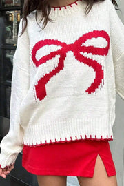 White knit crewneck sweater with red graphic bow and red scalloped trim.