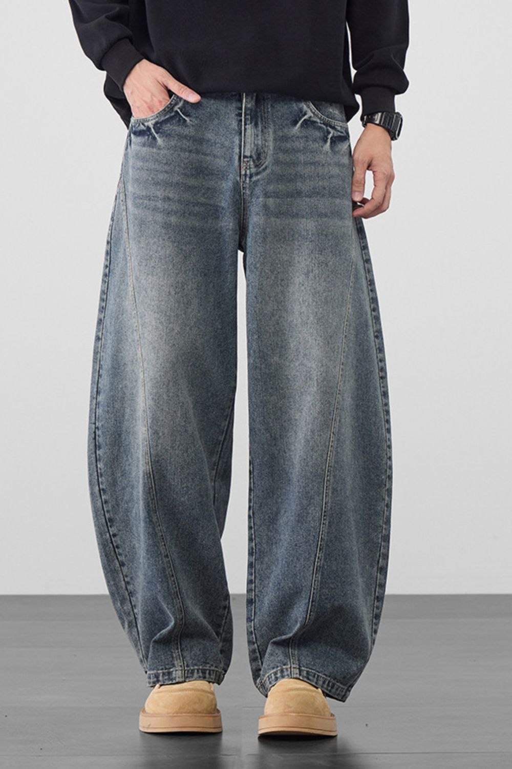Men's medium wash denim jeans with oversized wide legs and a relaxed fit.