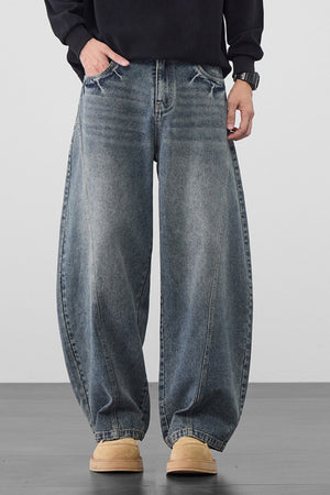 Men's medium wash denim jeans with oversized wide legs and a relaxed fit.