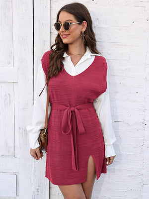 Deep Red knit vest dress with V-neck, tie waist, and side slit, worn over a white shirt.