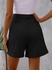 Black pleated bermuda shorts with cuffed hems and a cinched waist detail.