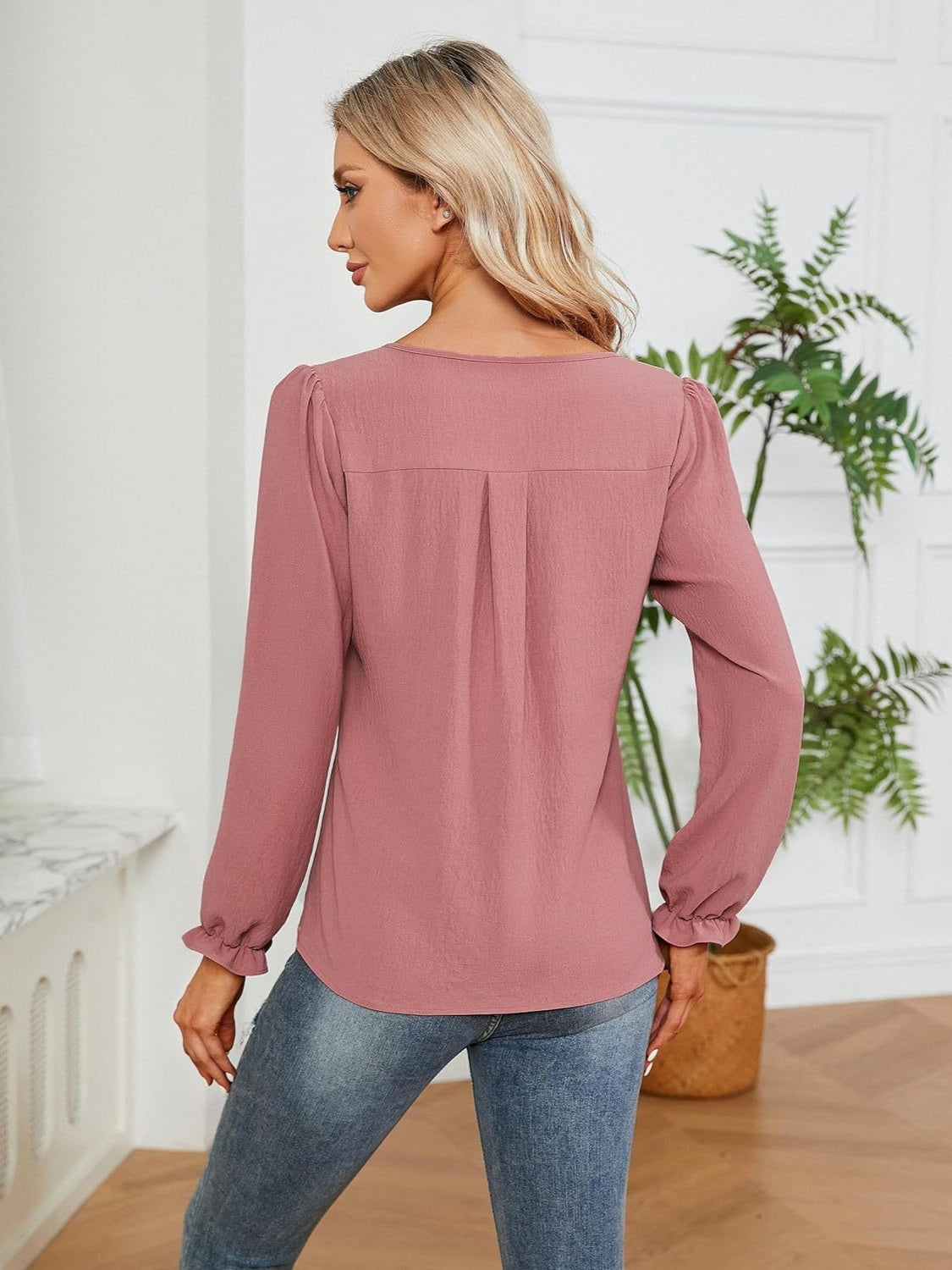 Dusty pink textured pleat-front blouse with ruffle cuffs and long sleeves.