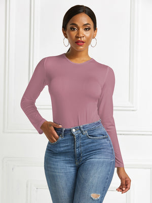 Sculpted ribbed jersey bodysuit in dusty pink with long sleeves and crew neck, styled with jeans.