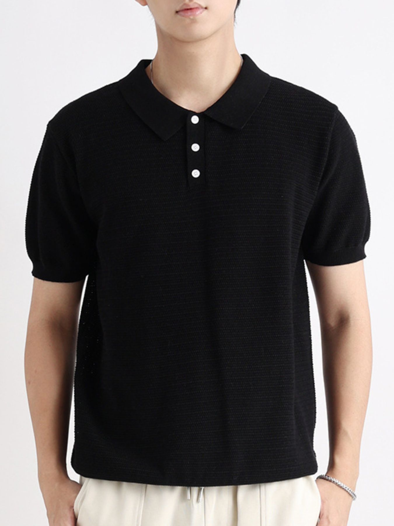 Black cotton short-sleeve polo shirt with button detail and textured knit