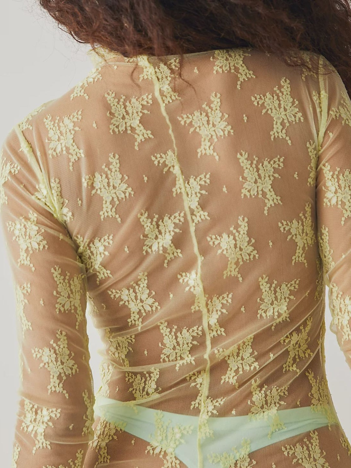 Sheer lime floral lace mock neck blouse with long sleeves.