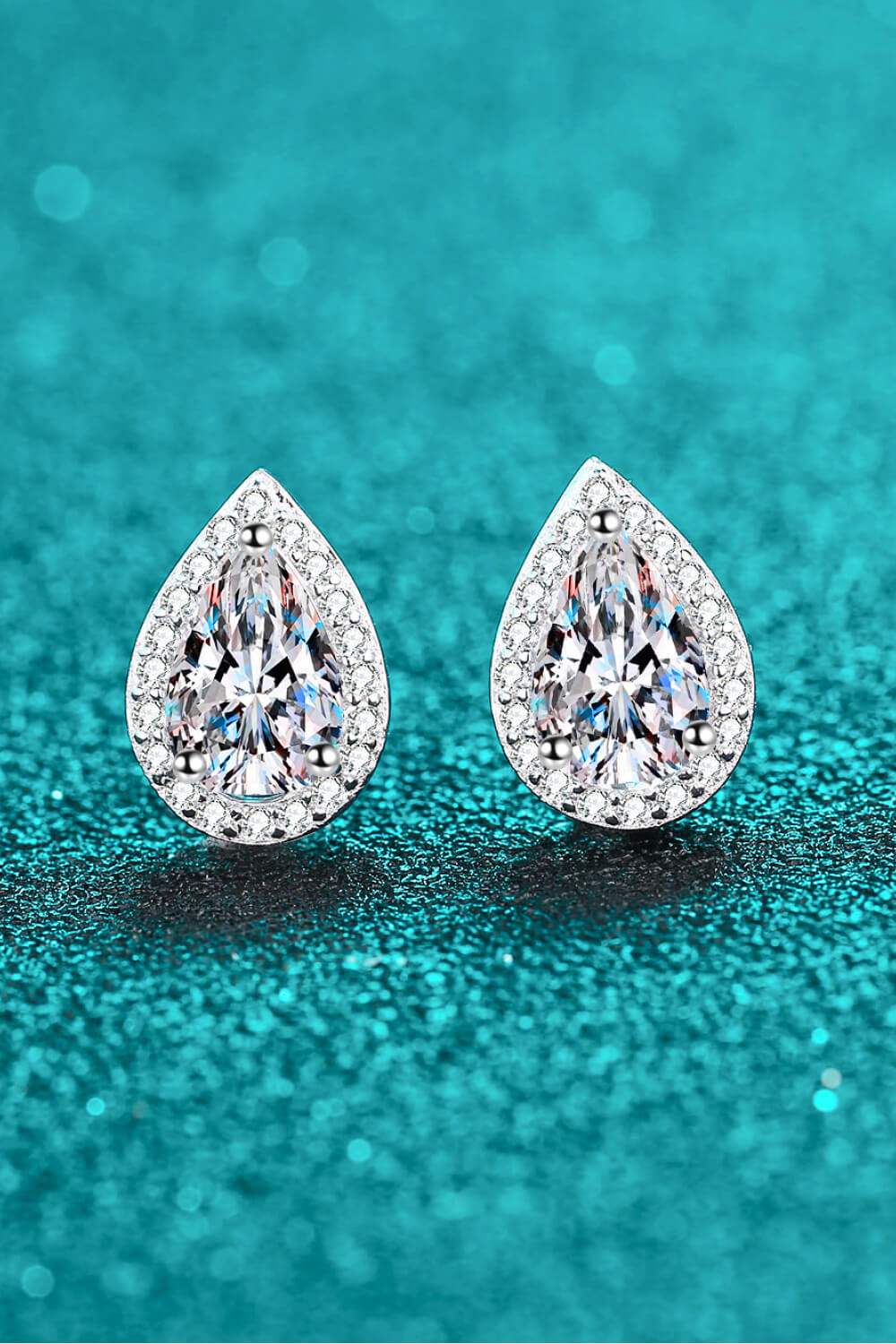 Silver teardrop halo earrings with pavé accents and a central faceted gem.