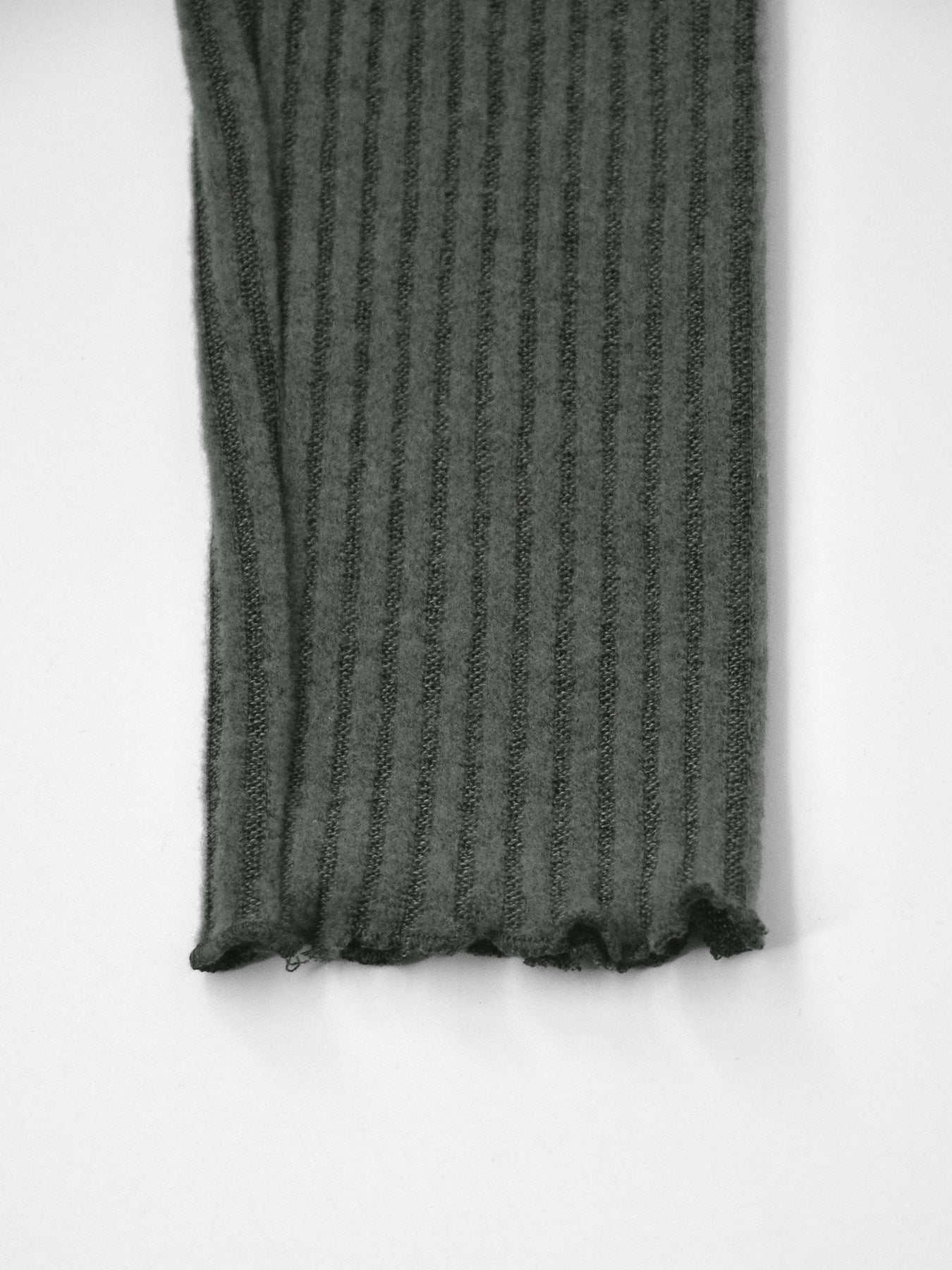 Dark gray ribbed knit top with lettuce hem detail