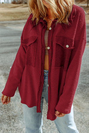 Red button-up coat with textured fabric and chest pockets