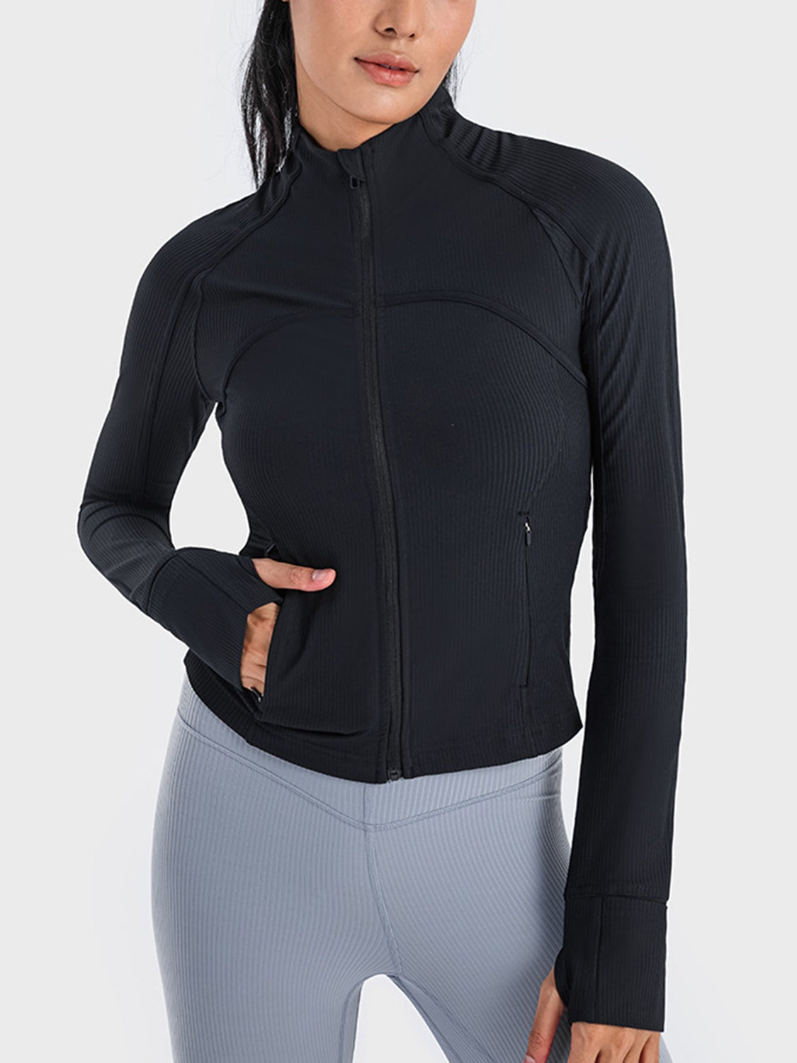 Black ribbed performance zip-up jacket with thumbholes and zippered pockets.