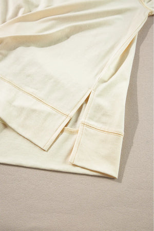 Pastel yellow blouse with side slits and reinforced hem detail.