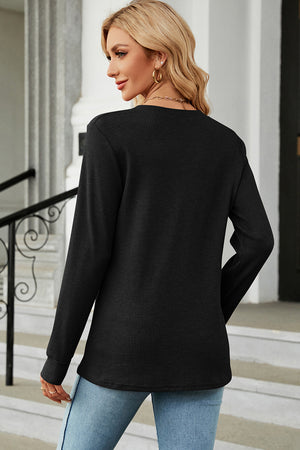 Black waffle knit henley shirt with button placket and long sleeves.