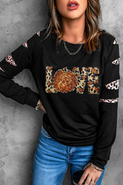 Black graphic sweatshirt with leopard print and sequin pumpkin detail. Cutout sleeves.
