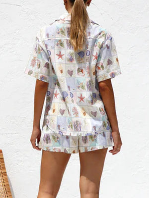 Resort set with short-sleeve button-up shirt and shorts in a multicolor coastal print.