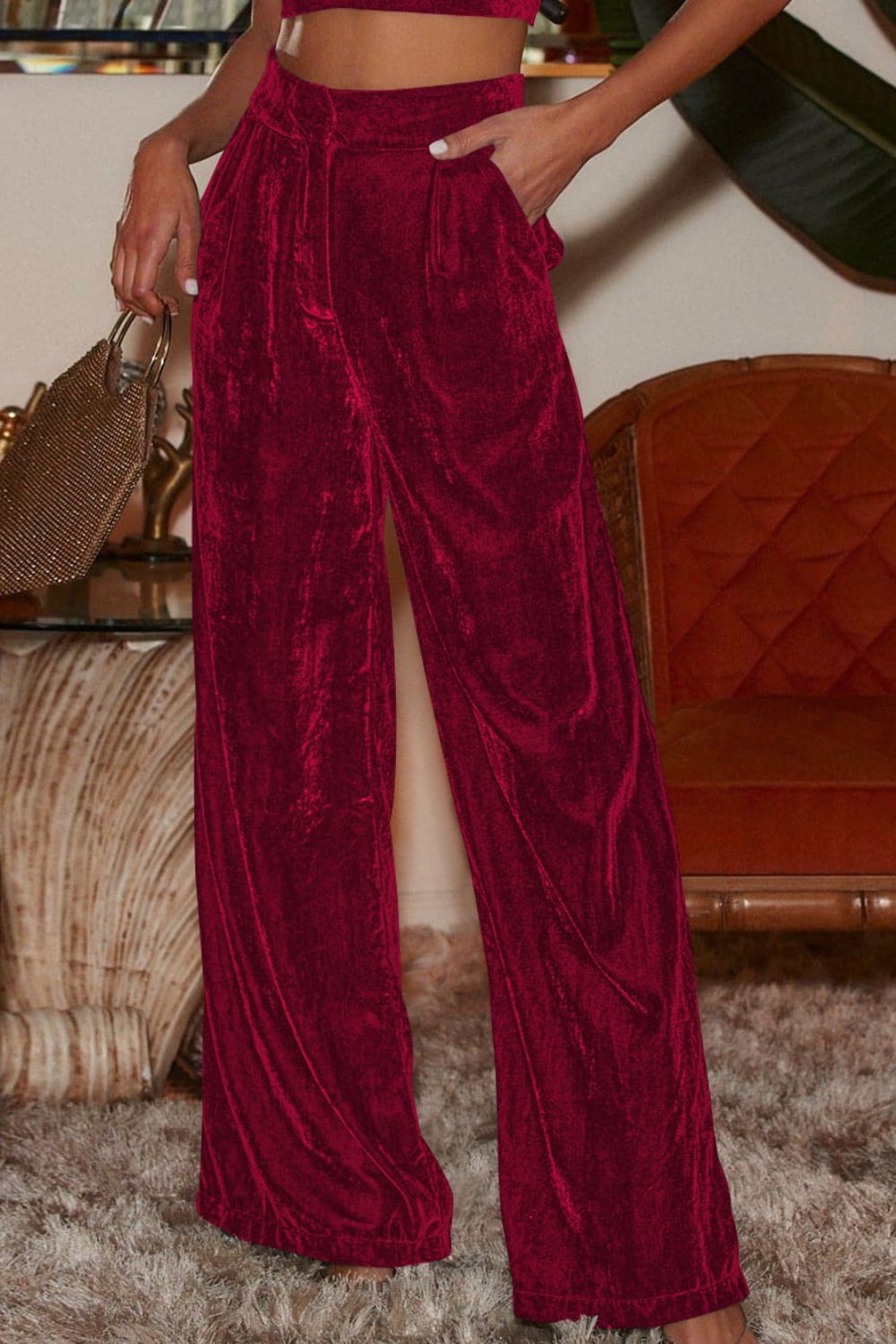 Burgundy velvet palazzo trousers with high waist and wide legs.