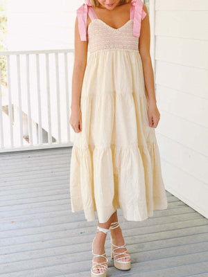 Cream tiered midi dress with smocked bodice and pink tie shoulders.