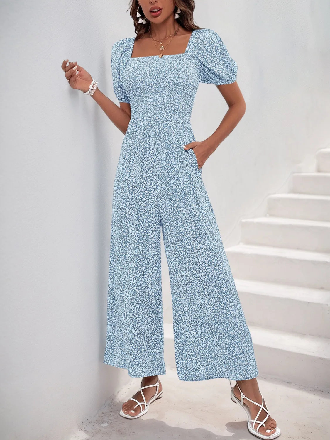 Light Blue floral smocked bodice jumpsuit with puff sleeves and wide legs.