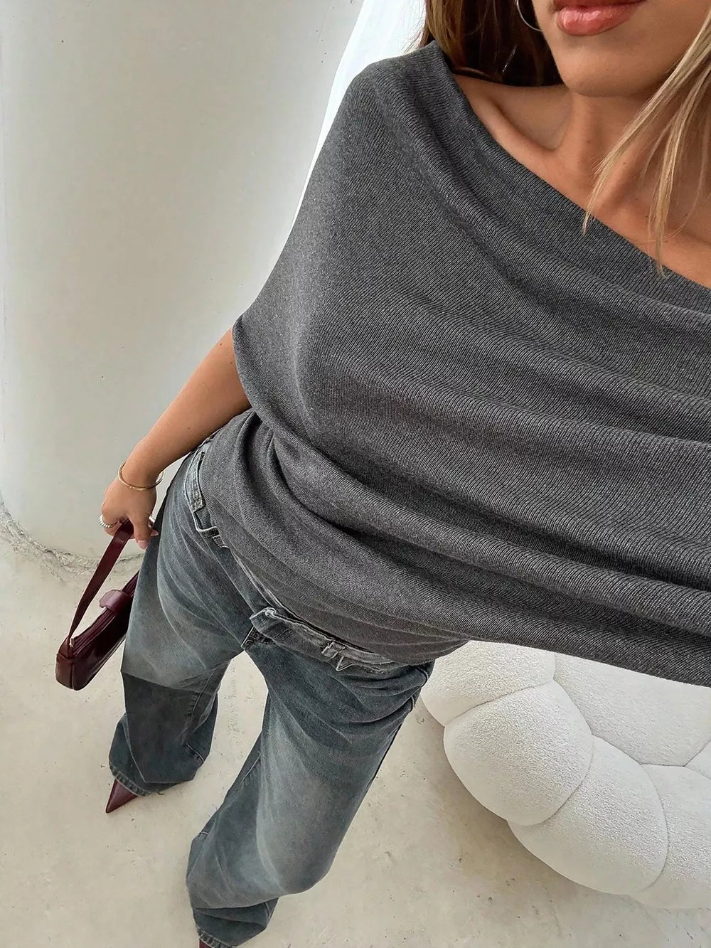 Dark gray ruched off-shoulder knit t-shirt with a draped neckline.