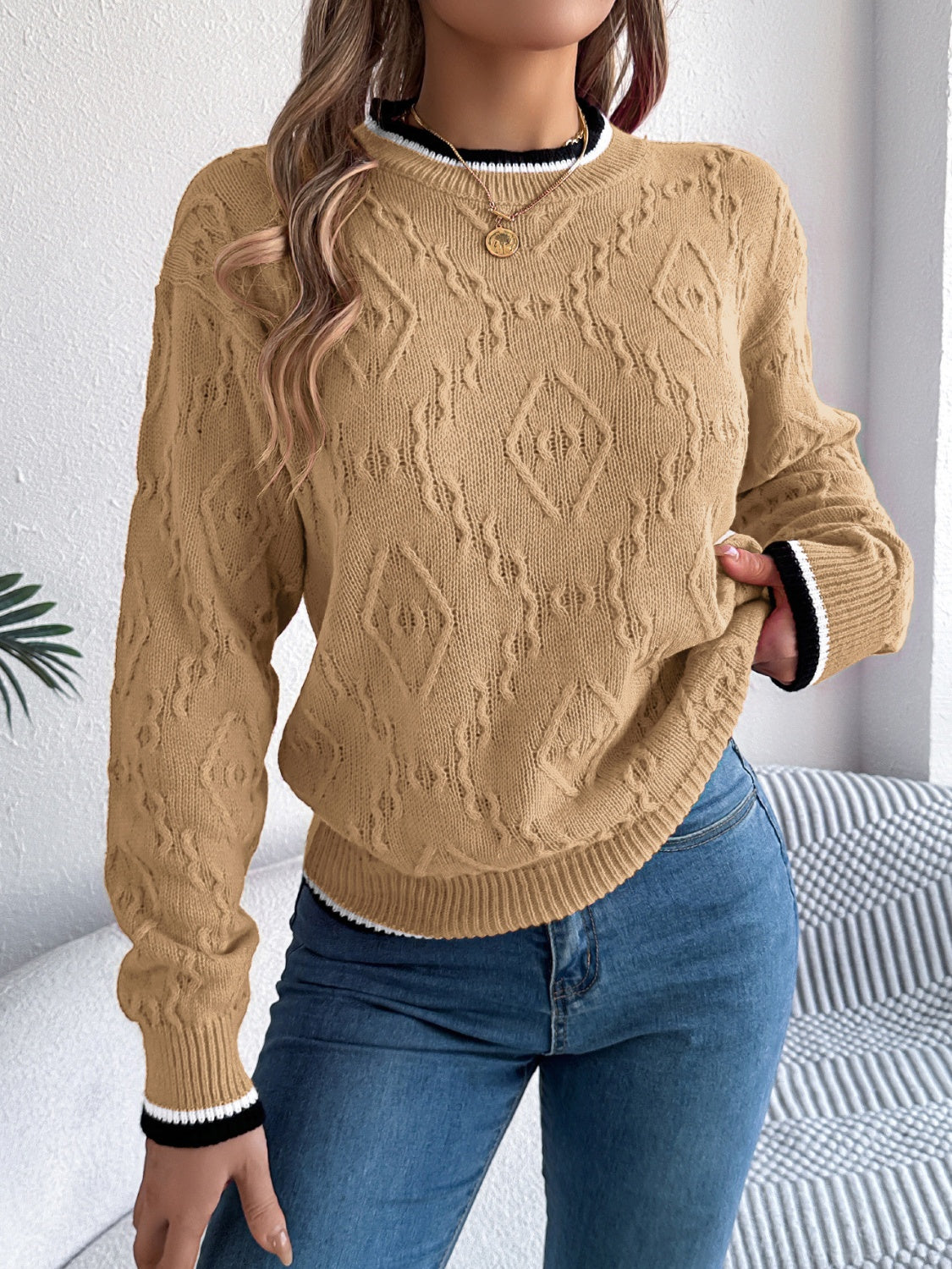 Tan diamond knit sweater with contrast trim neckline and cuffs.
