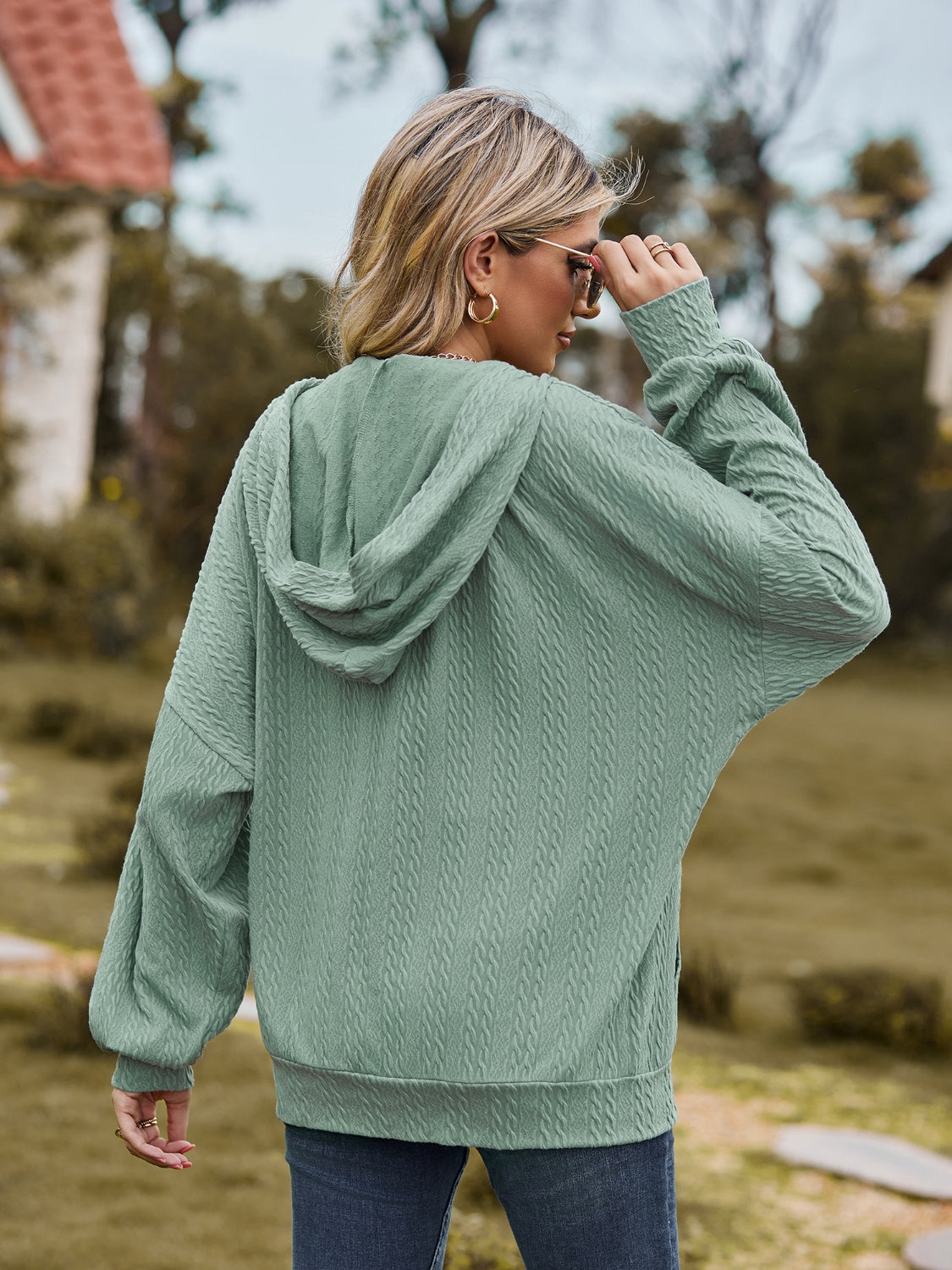 Sage green textured knit dolman sleeve hoodie with a hood and cuffed sleeves.