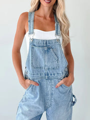 Light wash denim overalls with wide straps, bib pocket, and relaxed fit.