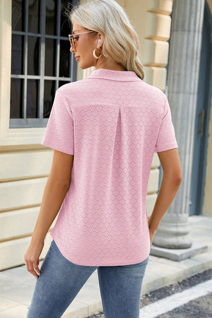 Textured blush pink polo shirt with V-neck detail and short sleeves.